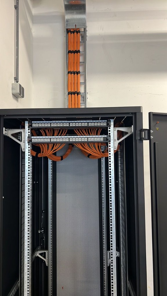 White cables in symmetrical loops into rear patch panels