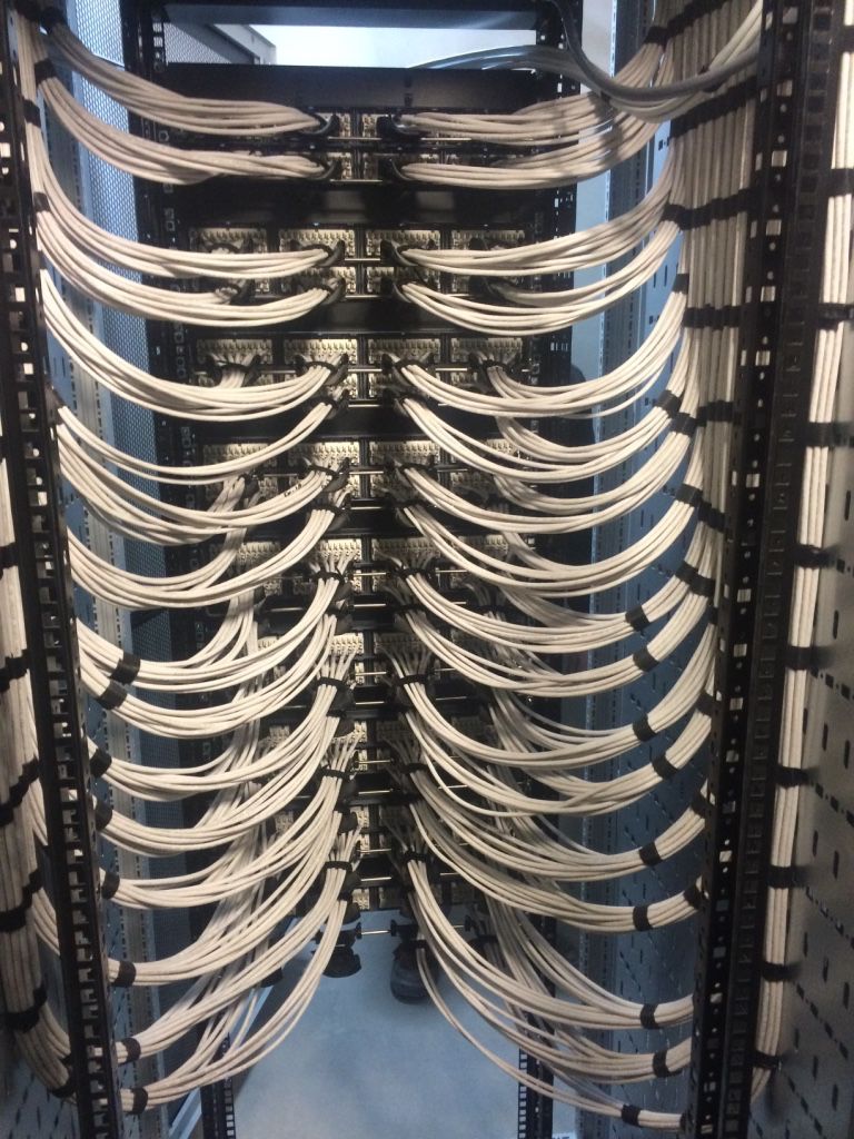 Close-up of orange cabling dressed into patch panels