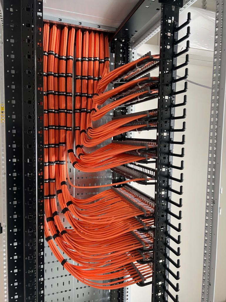 Blue cables terminated into a silver patch cabinet