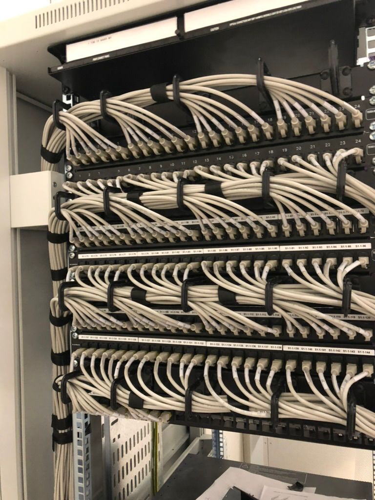 Labeled white cables terminated in numbered patch panels