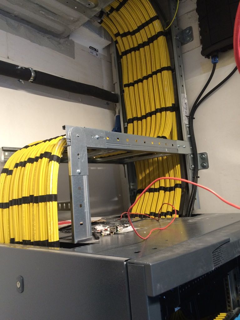 Orange cabling inside a white rack with power distribution