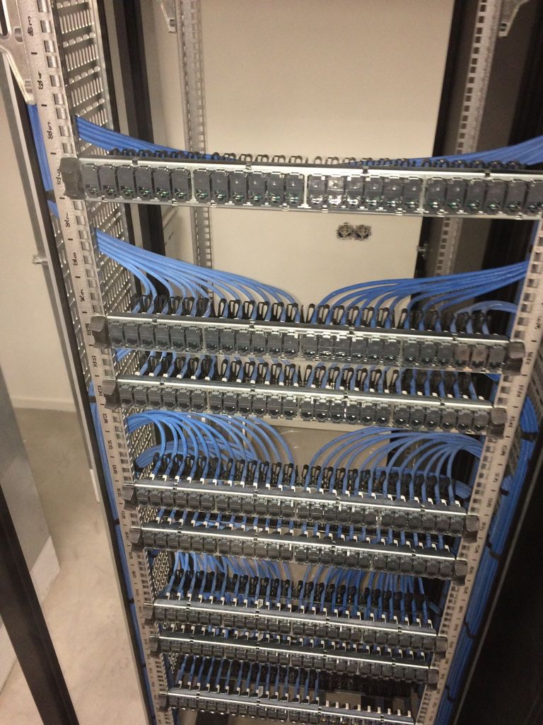 Orange cables entering the top of an open patch cabinet